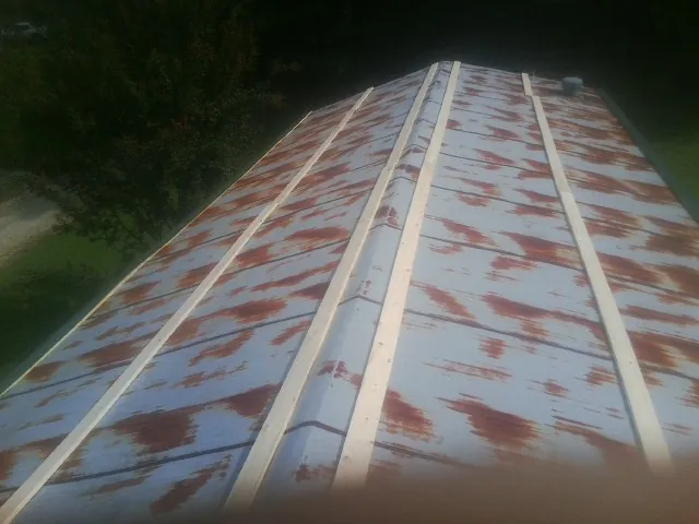 Rusted metal roof panels with new wood purlins before replacement — Storm Damage Roof Repair in Keyport by Roofing Brothers