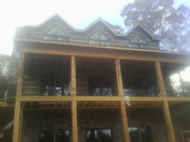 Dormers and porch framing on a large log home under construction — Roof Coating work by our crew in Keyport