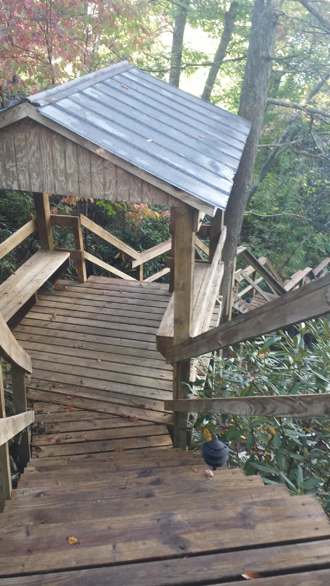 Metal roofed shelter over wooden steps on a wooded walkway — Skylight Repair & Installation work by our crew in Keyport